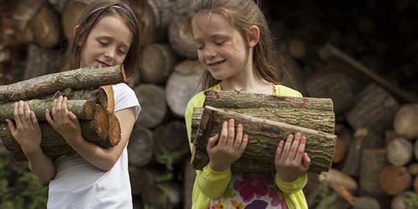 Young children carrying chopped wood