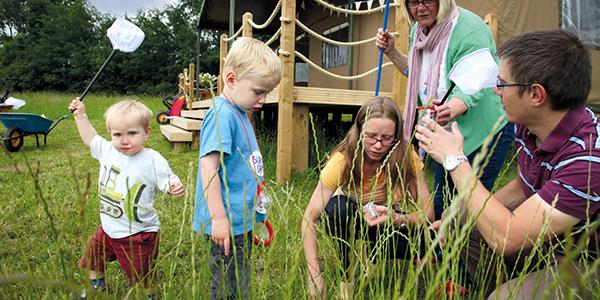 Young family having fun by glamping campsite