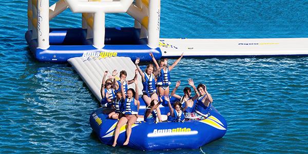 People having fun on aqua glide aqua park Rutland Water