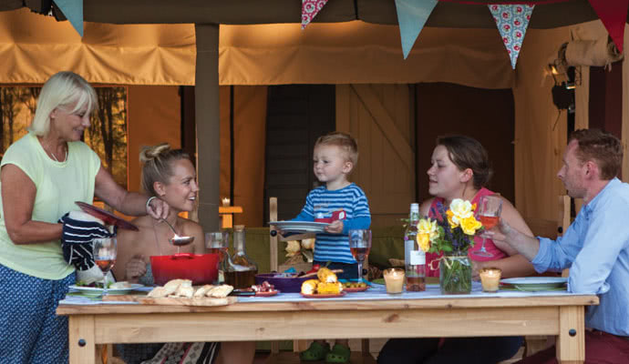 Family enjoying a meal whilst on their glamping holiday