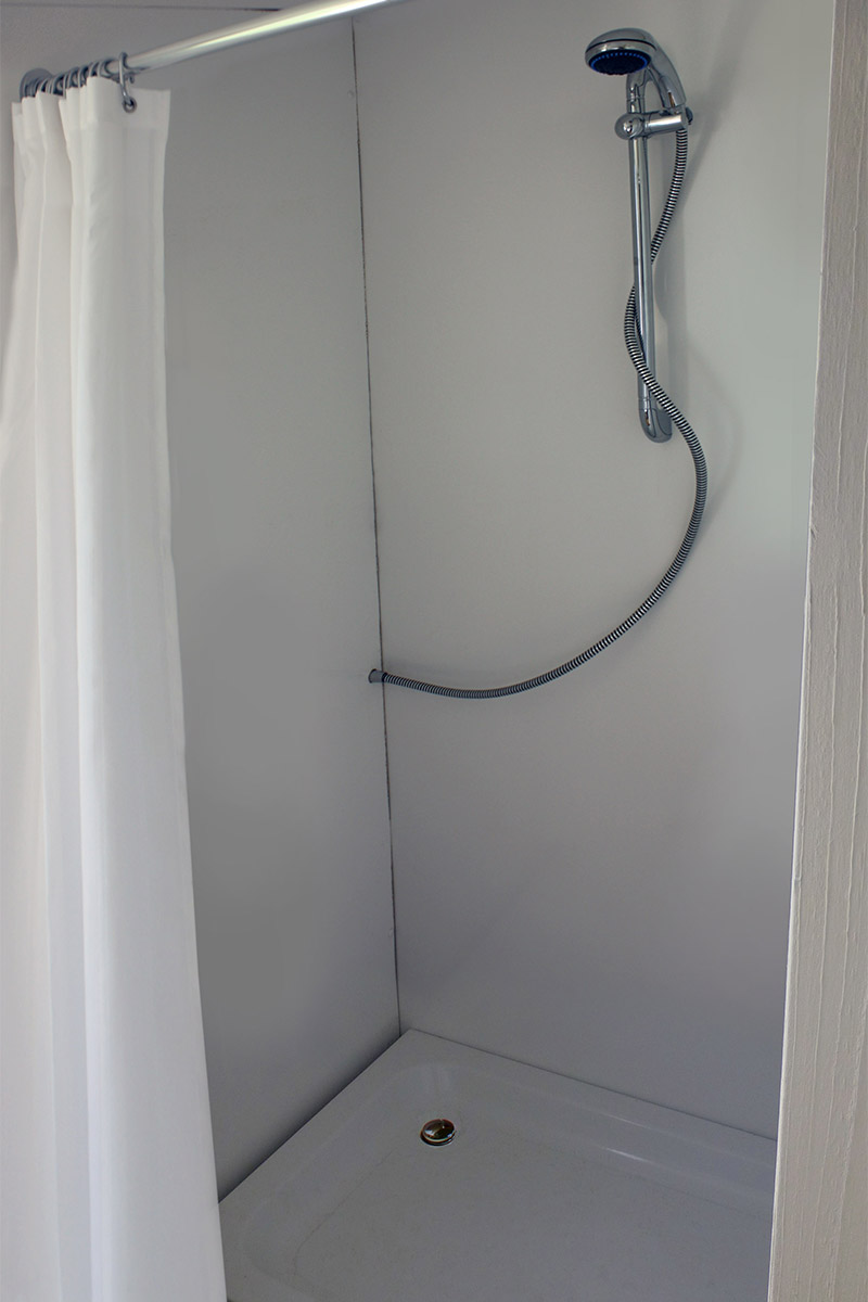 An adjustable shower with shower curtain in the shower room