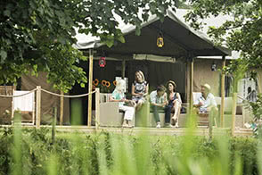 Friends and family chatting and having a drink outside the tent - thumbnail