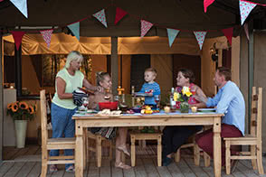 Family having a festive meal outside the tent - thumbnail