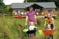 Parents wheelbarrowing their kids - thumbnail