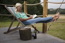 Woman drawing whilst enjoying a glass of wine on a glamping site - thumbnail