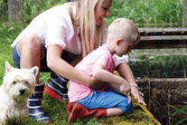 Mum, son and a puppy playing outdoors - thumbnail