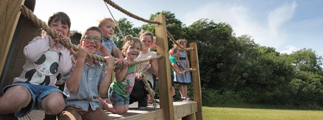 Children smiling and playing in the decking area of the glamping tent
