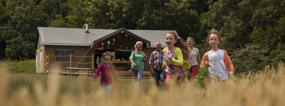 Family goes out of the glamping tent into the fields in Sweffling glamping site